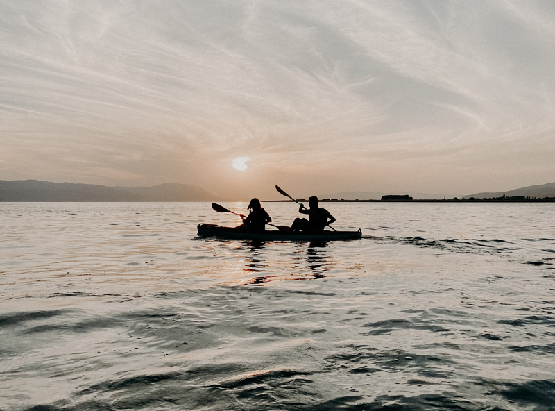 two people paddle a kayak on lake champlain