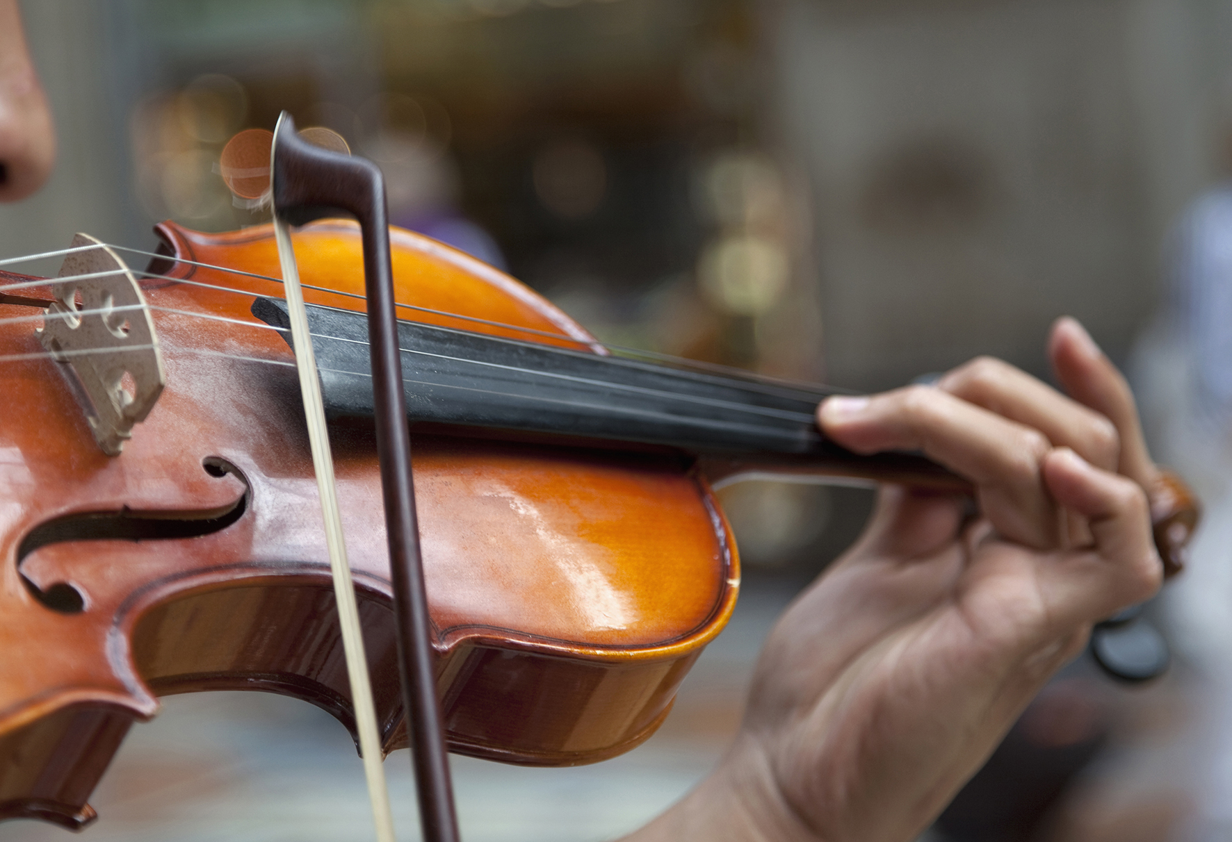 detail view man playing violin in public